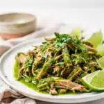 Slow cooker salsa verde pork taco with cilantro and cotija cheese garnish.