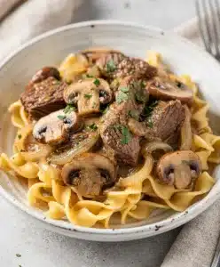Creamy slow cooker beef stroganoff with tender beef and mushrooms over noodles.