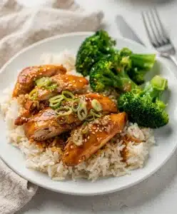 Slow cooker honey garlic chicken with glossy sticky sauce and tender shredded meat
