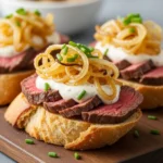 Steak crostini with horseradish sauce and caramelized onions on toasted baguette.