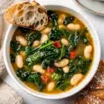 Creamy Tuscan white bean kale soup garnished with Parmesan and olive oil