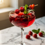 Romantic Valentine's berry mocktail spritzer in a coupe glass garnished with fruit.