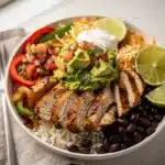 Colorful chicken fajita bowl with peppers onions rice beans and avocado