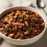 Classic beef bean chili with cheese and sour cream on cornbread side