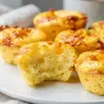 Fluffy golden brown cottage cheese egg bites in a white ceramic muffin tin