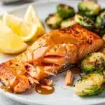 Maple Dijon salmon with crispy skin and glossy glaze on white plate
