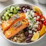 Mediterranean salmon bowls with quinoa, fresh vegetables, feta, and lemon herb dressing.
