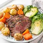 Oven roasted corned beef and cabbage recipe on a rustic wooden board