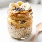 Creamy peanut butter banana overnight oats in a jar with chia seeds.