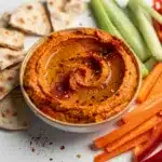 Creamy roasted red pepper walnut dip with rustic wood and linen napkin
