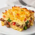 Sausage hash brown breakfast casserole with crispy cheese and savory sausage chunks.