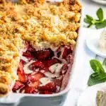 Overhead view of rustic strawberry white chocolate dump cake in ceramic dish.