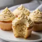 Classic vanilla cupcakes with creamy buttercream swirl on a clean plate.