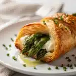 Golden brown puff pastry bundles wrapped around fresh green asparagus spears.