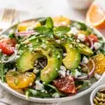 Avocado citrus salad with mixed greens red onion and toasted pepitas