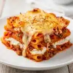 Cheesy baked ziti with bubbling mozzarella and rich meat sauce in a dish