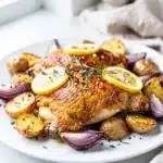 Sheet pan lemon chicken with crispy potatoes and fresh herbs close up