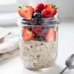 Creamy overnight oats with berries in a clear glass mason jar