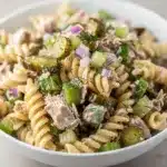 Creamy dill pickle tuna pasta salad with Greek yogurt dressing in white bowl.