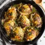 Golden seared garlic herb chicken thighs in glossy pan sauce with parsley