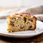 Moist Greek yogurt banana bread slice with walnuts on rustic board