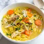 Lemon chicken orzo soup with tender chicken and vegetables in lemony broth