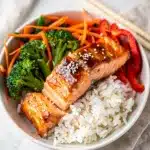 Flaky teriyaki salmon with broccoli and carrots over white rice.