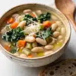 Creamy Tuscan white bean soup with kale in a rustic bowl.