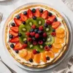 Bakery style fruit pizza with cream cheese frosting and fresh glazed berries
