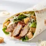 Crisp romaine and grilled chicken in a creamy Caesar wrap recipe.
