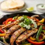 Golden brown chicken fajita skillet with colorful peppers and fresh toppings.