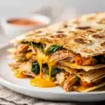 Golden crispy chicken and spinach quesadilla with melted cheese and fresh salsa