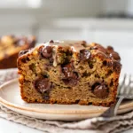 Moist chocolate chip banana bread slice with glossy brown sugar glaze.