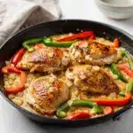 Creamy chicken skillet dinner with bell peppers in a rustic cast iron pan