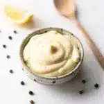 Creamy garlic aioli recipe in a rustic bowl with roasted garlic and lemon