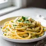 Creamy garlic parmesan pasta recipe with fettuccine, fresh parsley, and grated cheese.