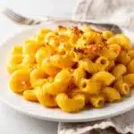 Creamy mac and cheese with cavatappi pasta in a white ceramic bowl.