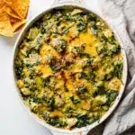 Creamy spinach artichoke dip baked golden and bubbly with chips and bread.