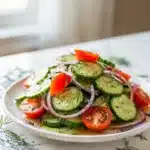 Fresh cucumber salad with tomatoes and herbs in a bright picnic style.