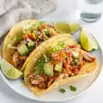 Creamy shredded chicken tacos with fresh avocado and crisp lettuce toppings.