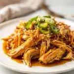 Crockpot honey garlic chicken served over rice with broccoli and green onions