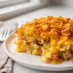 Golden bubbly crockpot hashbrown casserole with creamy cheese and crispy cornflake topping.