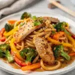 Easy udon stir fry recipe with chicken, broccoli, and glossy sauce.