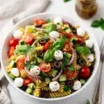 Colorful rotini pasta salad with fresh vegetables and Italian vinaigrette dressing.