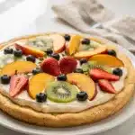 Seasonal fruit pizza on sugar cookie crust with creamy vanilla frosting and berries