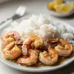 Plump garlic butter shrimp nestled in fluffy rice with creamy sauce