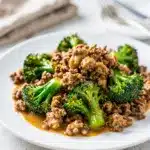 Ground beef and broccoli stir fry in glossy savory sauce with chopsticks