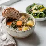 Hearty lentil vegetable soup with kale and crusty bread for dipping.
