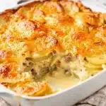 Creamy homestyle scalloped potatoes with golden cheese crust and fresh thyme