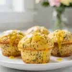 Moist lemon poppy seed muffins with a sweet creamy glaze close up